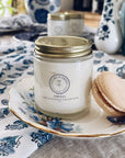 Amelia Vanilla Whipped Tallow Balm on decorative plate with macaron, nourishing skin moisturizer in glass jar.