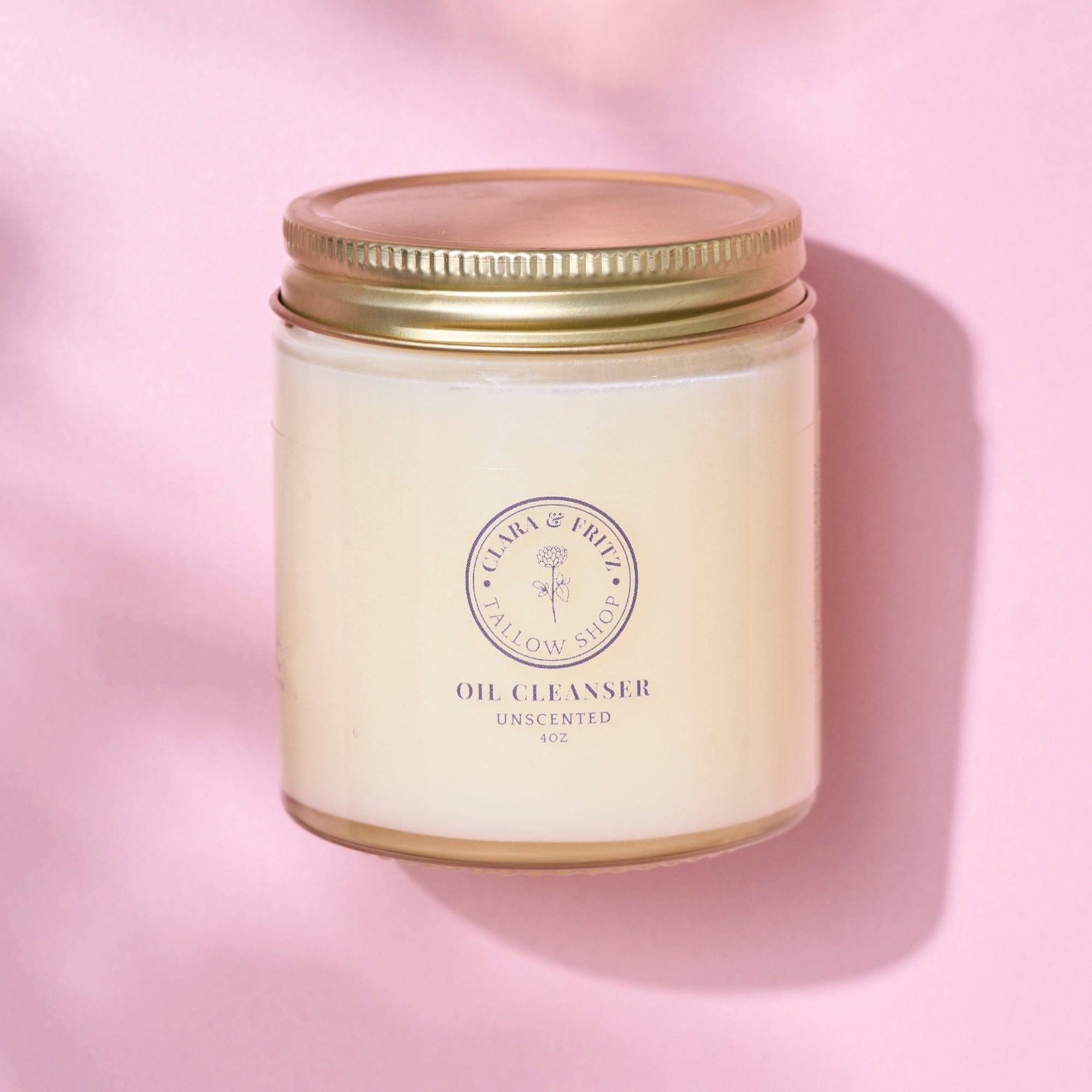 Tallow-Based Oil Cleanser in jar on pink background for balanced skin