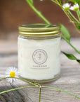 Jar of Clara & Fritz Unscented Whipped Tallow Balm moisturizer, surrounded by flowers, showcasing natural skincare product.