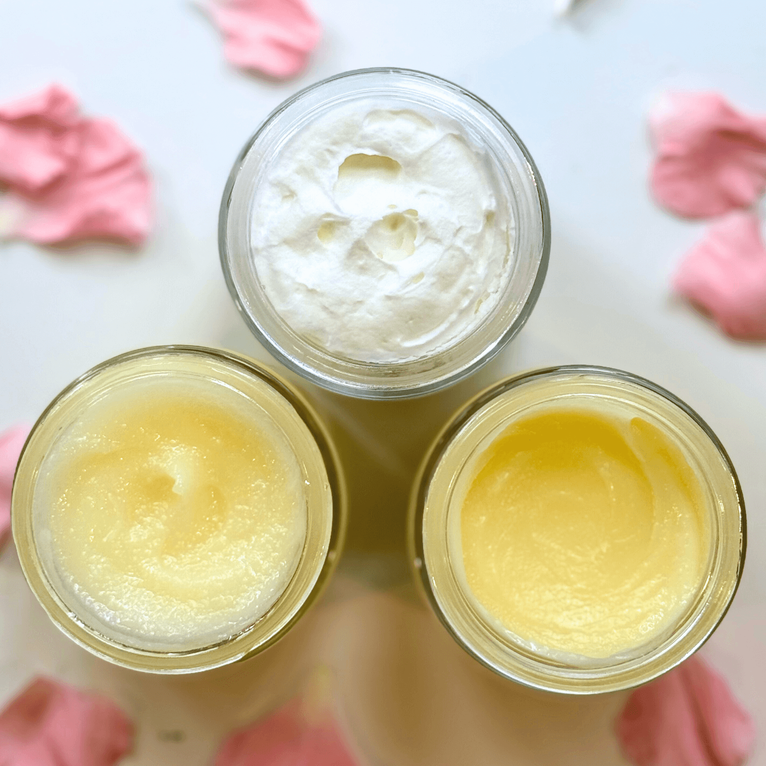 Daily Facial Trio from Clara & Fritz featuring tallow based skincare products in jars on white background with pink petals.