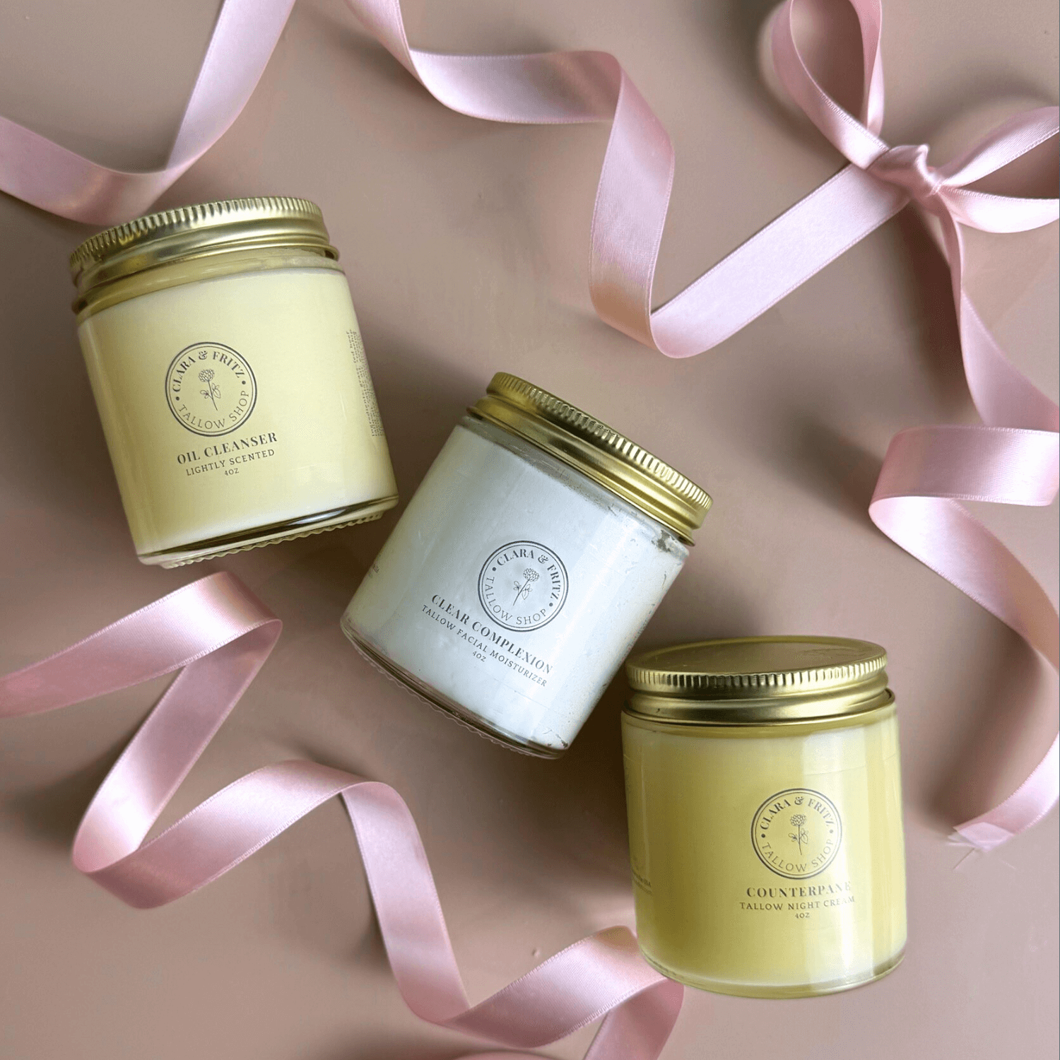 Daily Facial Trio from Clara & Fritz featuring tallow based skincare products in elegant jars with pink ribbon accents.