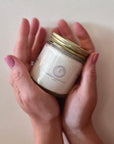 Hands holding a jar of scented whipped tallow balm, showcasing luxurious and nourishing moisturizer with natural ingredients.