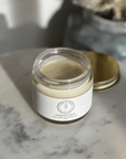 Natural Deodorant in a glass jar, tallow-based and non-toxic, shown on a marble surface.