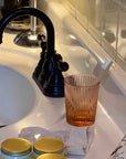 Garden Rose Juice Glass on bathroom vanity with toothbrush next to modern sink faucet