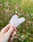 Rose Quartz Gua Sha Tool held by a left hand