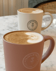 Clara & Fritz Latte Mug on a table with latte art, perfect for coffee lovers, ideal gift mug featuring stylish logo design.