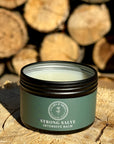 Strong Salve product in front of logs