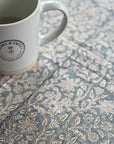 Seaside Garden Block Print Tablecloth with floral design, perfect for alfresco dining, shown with Clara & Fritz Latte Mug, handcrafted in Jaipur.