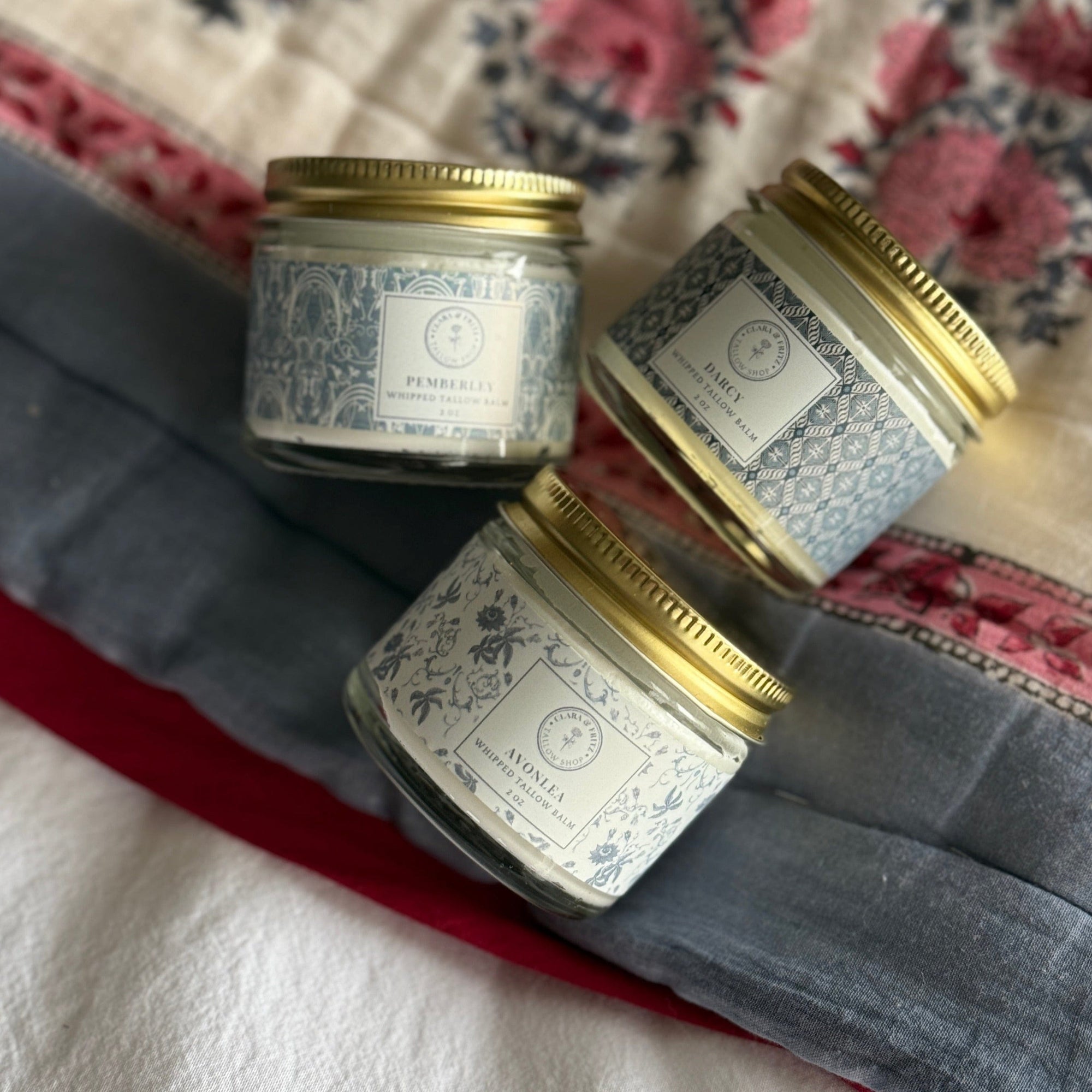 Signature Scent Trio Whipped Moisturizer Set jars on floral cloth background