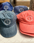 Multiple Garment-Washed Logo Hats in various colors featuring Clara & Fritz logo, perfect for style and comfort on sunny days.
