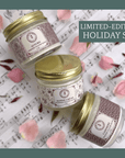 Limited-edition Seasonal Scent Gift Set balm jars on sheet music with flower petals.