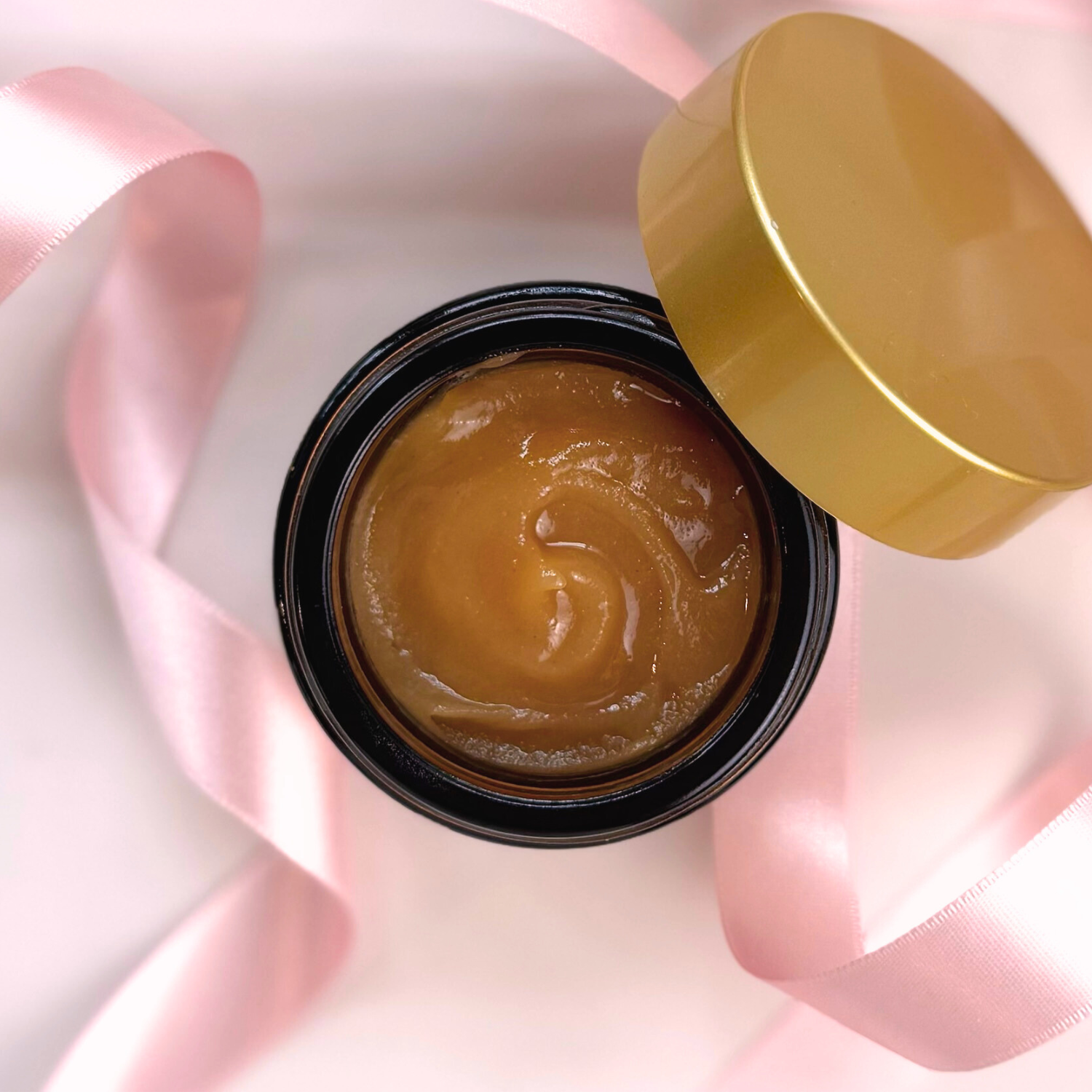 Open jar of Timeless Antioxidant Balm with luxurious gold lid and pink ribbon