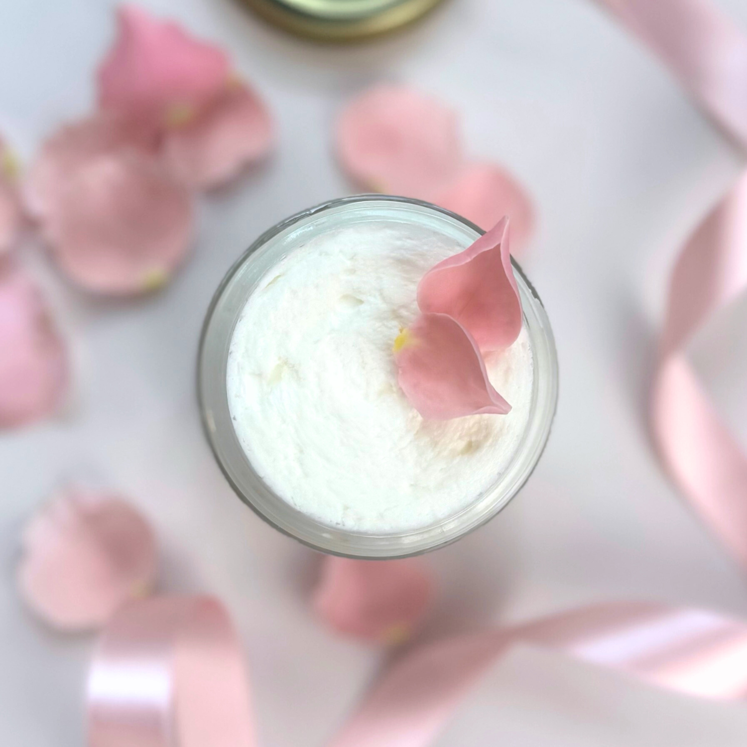 Top view of Clara & Fritz Unscented Whipped Tallow Balm in a jar with pink petals and ribbon, emphasizing pure skincare.