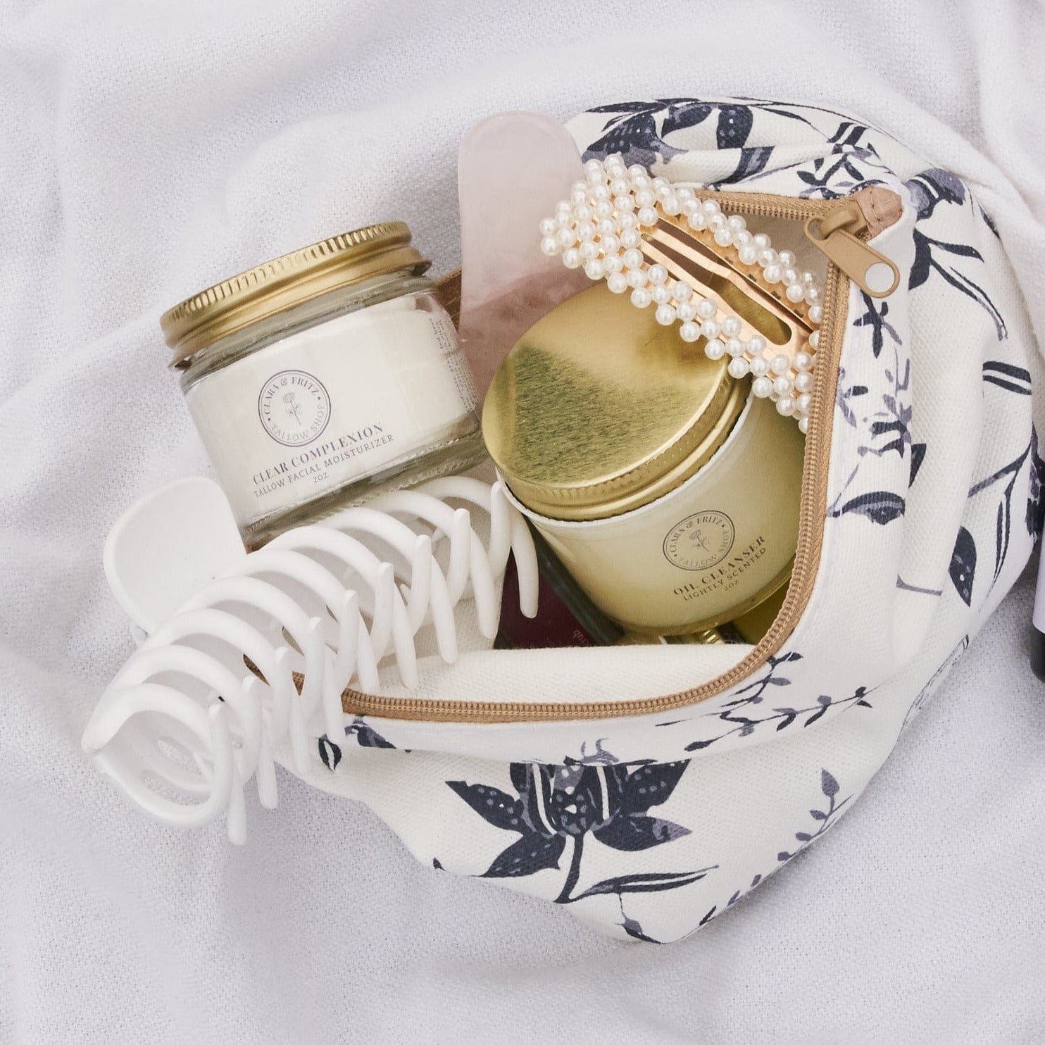 Clara & Fritz Beauty Bag with skincare products, hair clip, jade roller, and pearl hairpin. Exclusive Beauty Bag storage solution.