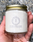 Clear Complexion Whipped Tallow Facial Moisturizer in a glass jar held in hand