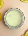 Natural Tallow Deodorant in a glass jar surrounded by lemon slices.