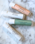 Tallow Lip Balm Set, 4-pack containing Orange Cream, Unscented, Peppermint, and Vanilla for deep hydration and soothing lips.