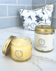 Open jar of Tallow-Based Oil Cleanser with a skincare jar and patterned pouch on a bathroom counter.