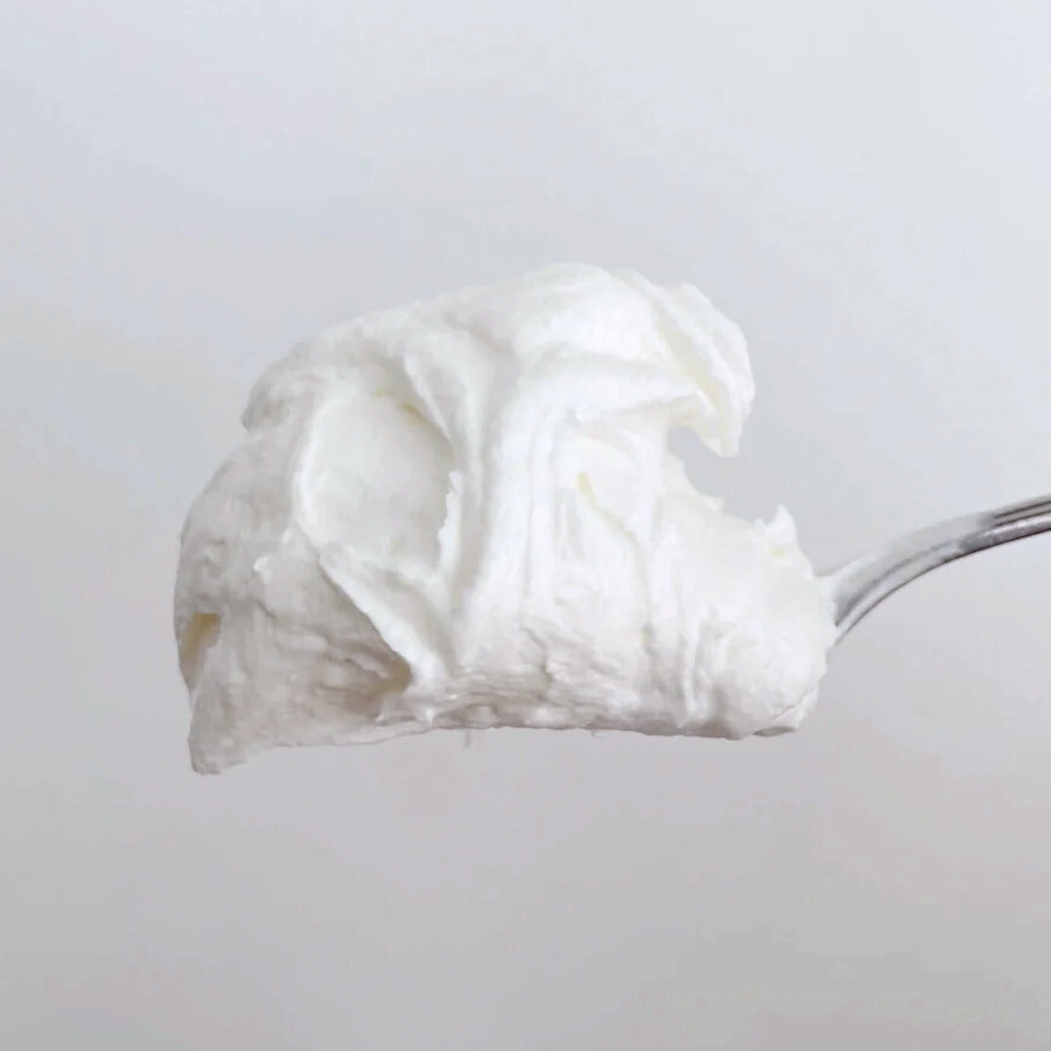 Spoonful of Unscented Whipped Tallow Balm showcasing its creamy texture.