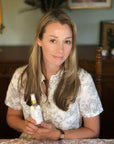 Founder holding Clear Complexion Refining Facial Mist bottle indoors