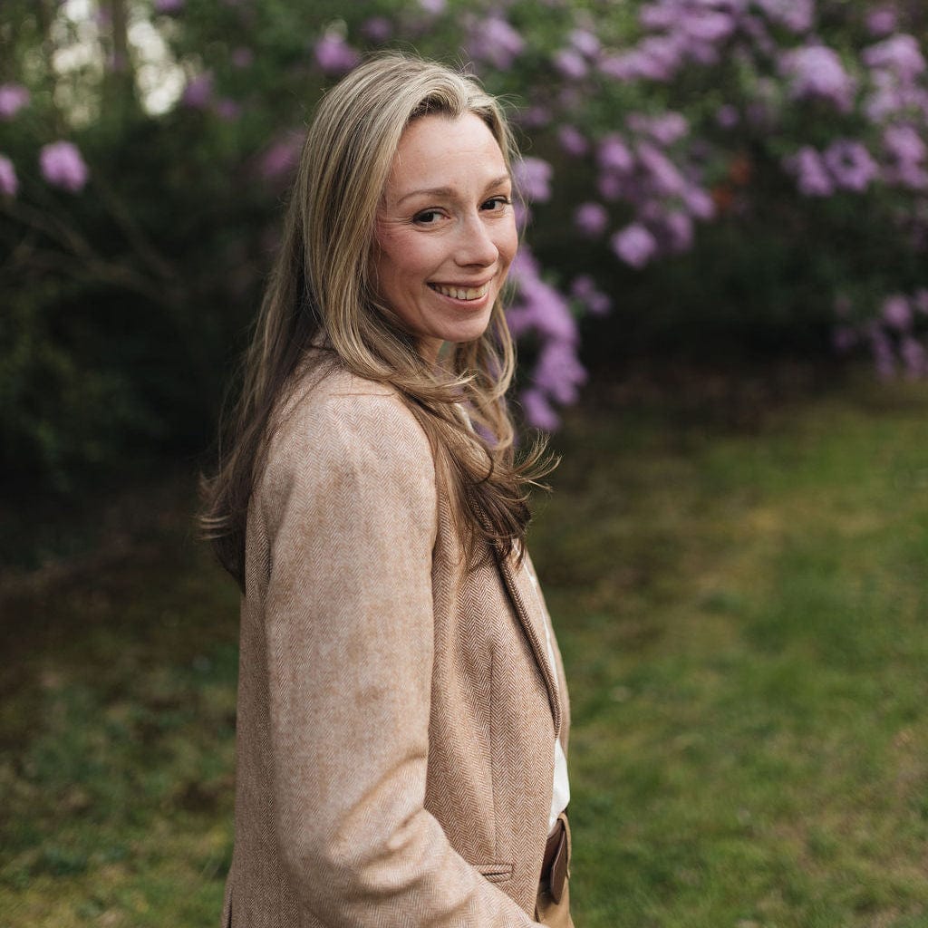 Woman standing in a garden with purple flowers in the background