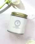 Glass jar of scented whipped tallow balm with floral elements, nourishing for skin.