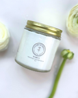 Jar of scented whipped tallow balm with golden lid on a white background