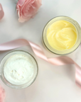 Day & Night Face Moisturizer Duo in jars with pink flowers and ribbon on a marble surface