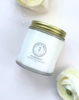 Scented whipped tallow balm in a glass jar with white flowers, luxurious moisturizer for well-nourished skin.
