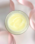 Clear Complexion Solid Moisturizer in a glass jar with pink ribbons for gentle skincare.